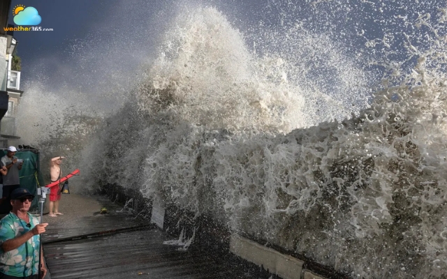 A wave surges over a small retaining wall in Long Beach, California, on September 6