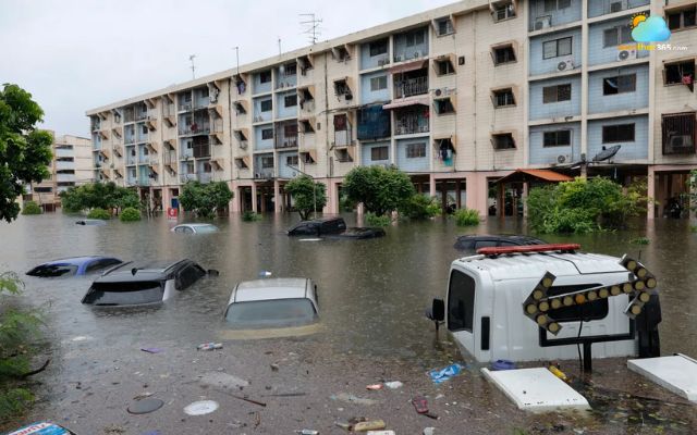 Cars submerged in floodwaters near residential buildings